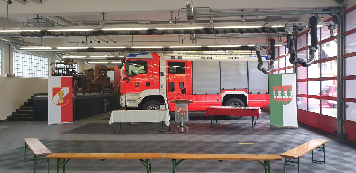 Eine Feuerwehrhalle mit Fahnen und Feuerwehrauto