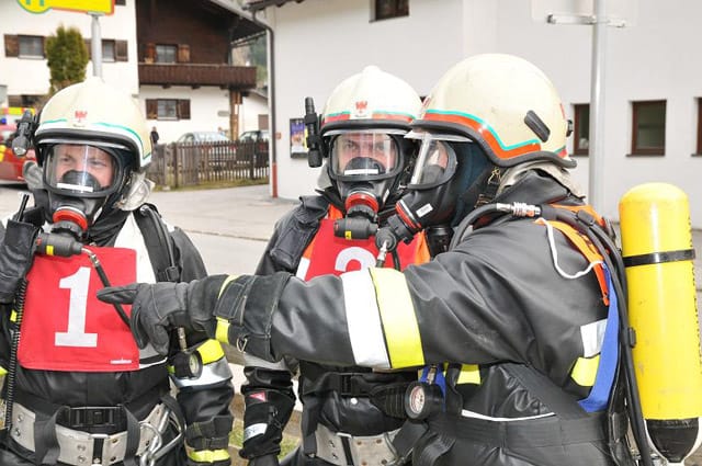 Vier Feuerwehrmänner mit Atemschutzausrüstung
